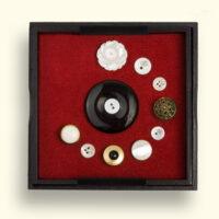 Onyx Mourning Button, in the box surrounded by buttons of loved ones secured with crystal pins. Sizes: L x W = about 125x125mm.